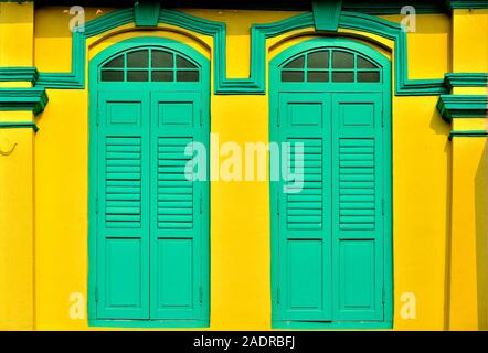 Vue avant du vintage boutique traditionnelle Singapour maison avec des volets en bois vert et jaune dans la ville historique de mur peu l'Inde, Singapour Banque D'Images