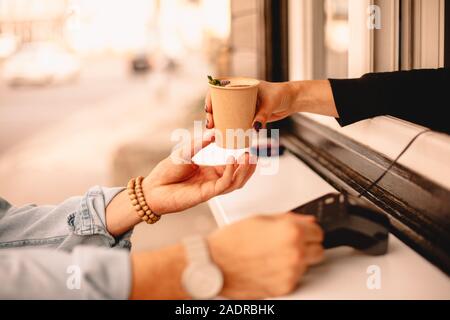 Café barista femelle donnant au client alors qu'il faire le versement Banque D'Images
