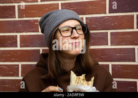 Une femme assise et la tenue de döner kebab. Banque D'Images