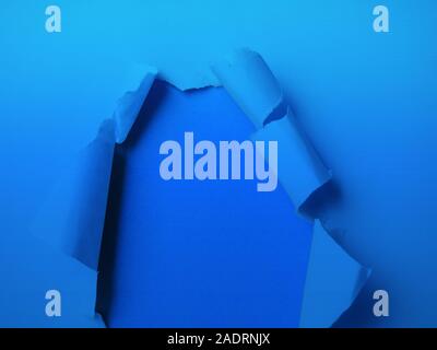 Bleu classique teinté, couleurs classiques en 2020, trou dans le papier avec côté déchiré. Papier déchiré sur couleur bleue classique Banque D'Images