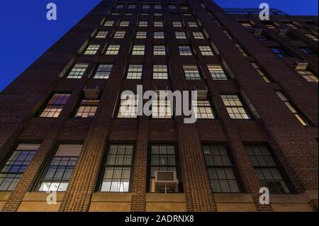 À la recherche jusqu'à la façade d'un grand bâtiment en brique, sur l'Upper East Side de Manhattan de nuit, New York City Banque D'Images