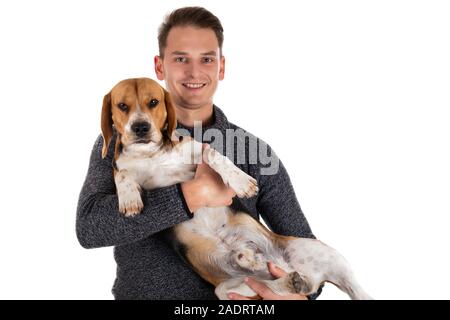 Jeune homme tenant un beagle adorable de couleur sur fond isolé Banque D'Images