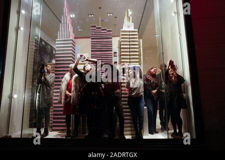 New York, États-Unis. 9Th Jul 2019. Un groupe de personnes de prendre des photos de l'intérieur d'une fenêtre d'affichage kate spade new york au magasin avant l'arbre de Noël les feux sont allumés pour la première fois à la 87e Cérémonie annuelle d'illumination de l'arbre de Noël du Rockefeller Center à New York le Mercredi, Décembre 4, 2019. Photo de John Angelillo/UPI UPI : Crédit/Alamy Live News Banque D'Images