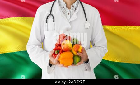 Médecin est maintenant les fruits et légumes dans les mains à l'arrière-plan du pavillon de la Bolivie. Concept national de santé, médicaux thème. Banque D'Images