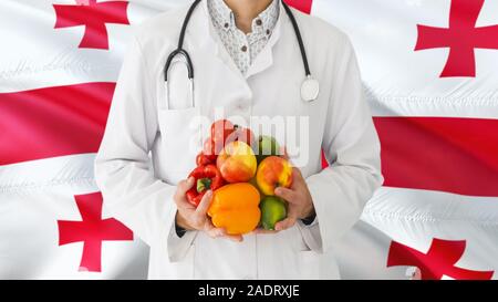 Médecin est maintenant les fruits et légumes dans les mains à l'arrière-plan. Le drapeau de la Géorgie Concept national de santé, médicaux thème. Banque D'Images