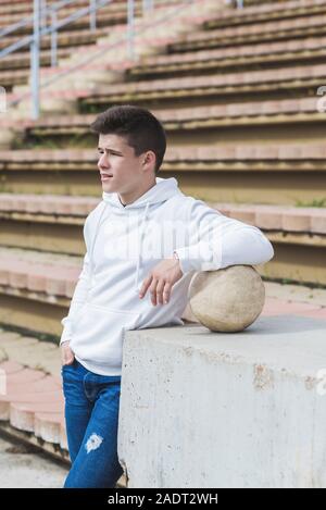 Jeune homme pensif standing outdoors Banque D'Images