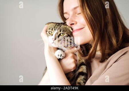 Young woman holding beau chat sur fond blanc Banque D'Images