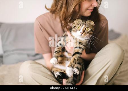 Young woman holding beau chat sur fond blanc Banque D'Images