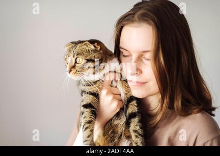 Young woman holding beau chat sur fond blanc Banque D'Images