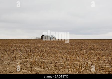 Le tracteur s'étend de l'engrais organique sur le terrain sur un jour nuageux Banque D'Images