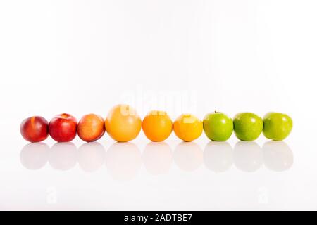 Fruits colorés standing in a row on white background isolés Banque D'Images