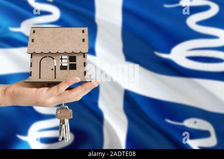 Woman hand holding maison en bois et les touches avec la main. Martinique drapeau avec concept de louer, achat, assurance, immobilier, construction maison écologique. Banque D'Images