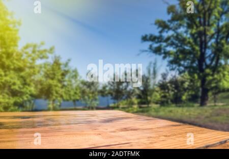 Terrasse en bois avec table vide flou d'arrière-plan du parc Banque D'Images