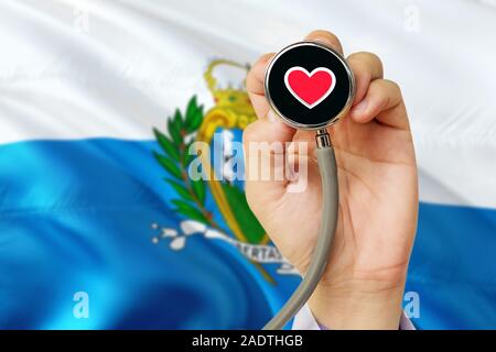 Doctor holding stethoscope avec amour rouge coeur. Drapeau national de Saint-Marin. Système de soins médicaux, concept thème. Banque D'Images