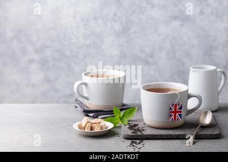 Le thé dans les tasses avec drapeau britannique plateau étiquette de sac. Fond gris. Copy space Banque D'Images