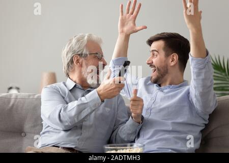 Heureux père et fils grandi célébrant la victoire de l'équipe de football Banque D'Images
