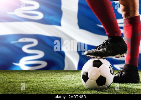 Close up jambes de joueur de l'équipe de football de la Martinique en rouge chaussettes, chaussures le ballon de soccer au point de penalty ou coup franc jouant sur l'herbe. Banque D'Images