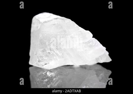 Pierre minéral calcite blanche en face de fond noir, de polymorphe de carbonate de calcium Banque D'Images