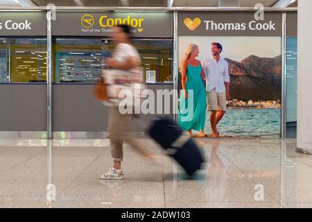 Palma, Espagne. 12 octobre, 2019. Une femme passe devant un bureau de Condor et Thomas Cook à l'aéroport de Palma de Majorque. Le sauvetage de la British groupe de tourisme Thomas Cook a échoué. Credit : Stephan Schulz/dpa-Zentralbild/ZB/dpa/Alamy Live News Banque D'Images