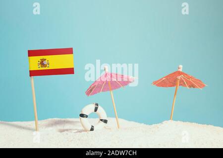 Pavillon de l'Espagne Miniature sur plage avec parasols colorés et conservateur de vie. Concept de voyage, thème d'été. Banque D'Images