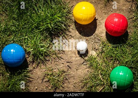 Un grand nombre de boules en plastique coloré ou balles de boccia se trouvent sur un pré vert à l'été Banque D'Images