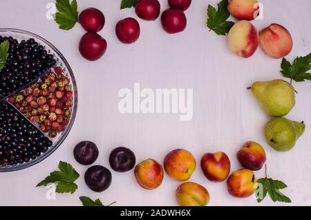 Image de fruits et de baies avec l'exemplaire de l'espace sur un fond en bois blanc à partir de prunes, pêches, nectarines, poires, cassis, fraises. Harvest Banque D'Images