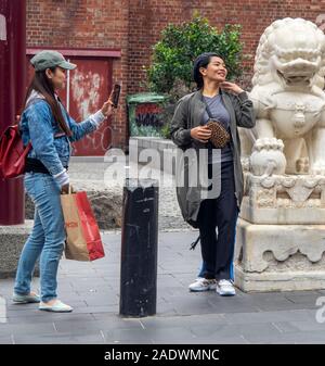 Deux touristes asiatiques posant pour in Chinatown Plaza Little Bourke Street Melbourne Victoria en Australie. Banque D'Images