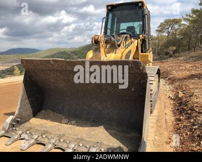 Seau de bulldozer sur chenilles. Le terrassement de la machinerie lourde sur la route de travaux de construction. Banque D'Images