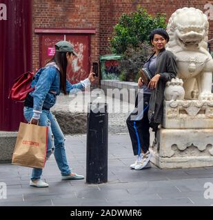 Deux touristes asiatiques posant pour in Chinatown Plaza Little Bourke Street Melbourne Victoria en Australie. Banque D'Images