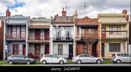 La rue Drummond voitures en stationnement en face d'une rangée de maisons en terrasse Carlton Melbourne Victoria en Australie. Banque D'Images