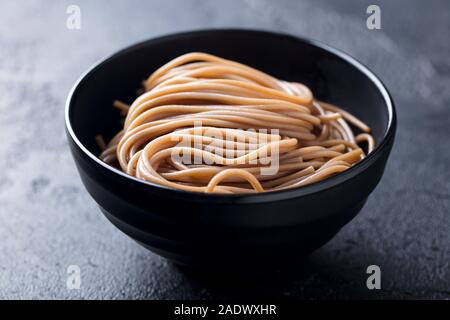 Nouilles Soba noire sur une cuvette. La nourriture japonaise. Fond d'ardoise. Close up Banque D'Images