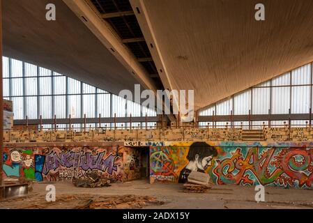 05 décembre 2019, la Saxe-Anhalt, Magdeburg : Dans l'intérieur de l'hyparschale de nombreux graffitis sont à voir. En face de lui se trouvent les restes d'un parquet. Depuis 1997, la salle polyvalente, qui a été construit selon les plans de l'architecte Ulrich Müther, a été fermé à l'immeuble de la police. Cette semaine, les 17 millions d'euros de mesures de restructuration ont commencé. Le Hyparschale Magderburger inscrit dans le Stadtpark Rotehorn est de devenir un établissement moderne pour les conférences, congrès et manifestations culturelles. Selon le plan, les travaux de construction dureront jusqu'à l'été 2022. Photo : Stephan Sch Banque D'Images