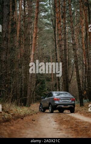 Minsk, Belarus - 21 novembre, 2019 : Lada Vesta robot AMT boîte de vitesses sur route de campagne n'automne paysages forestiers. Banque D'Images