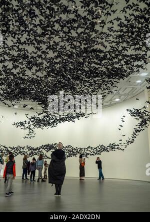 Personnes regardant 10 000 oiseaux Murmuration porcelaine suspendu (Paysage) installation à la National Gallery of Victoria NGV Melbourne Australie. Banque D'Images