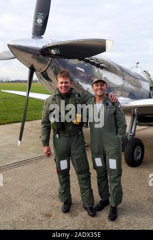 Pilotes britanniques Matt Jones (à gauche) et Steve Brooks, stand en face de l'IWC Spitfire MK IX L'argent après leur retour à l'Aérodrome de Goodwood, après le tour du monde avec succès dans le nouveau Spitfire restaurée. Banque D'Images