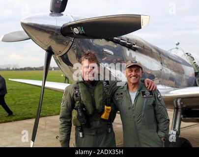 Pilotes britanniques Matt Jones (à gauche) et Steve Brooks, stand en face de l'IWC Spitfire MK IX L'argent après leur retour à l'Aérodrome de Goodwood, après le tour du monde avec succès dans le nouveau Spitfire restaurée. Banque D'Images