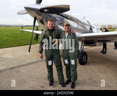 Pilotes britanniques Matt Jones (à gauche) et Steve Brooks, stand en face de l'IWC Spitfire MK IX L'argent après leur retour à l'Aérodrome de Goodwood, après le tour du monde avec succès dans le nouveau Spitfire restaurée. Banque D'Images