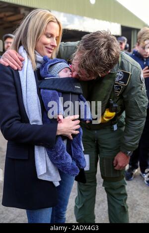 Pilote britannique Matt Jones est accueilli par son Nikkolay partenaire James et leur bébé de neuf semaines, Arthur Jones, de retour à l'Aérodrome de Goodwood, après le tour du monde avec succès dans la nouvelle 'restauré IWC Spitfire MK IX L'argent'. Banque D'Images