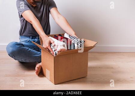 Femme mettant son linge dans un carboad fort. Banque D'Images