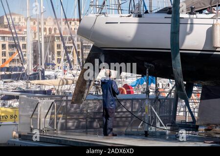 Homme de laver la coque d'un voilier en cale sèche au Vieux Port Vieux port de Marseille, France, Europe Banque D'Images