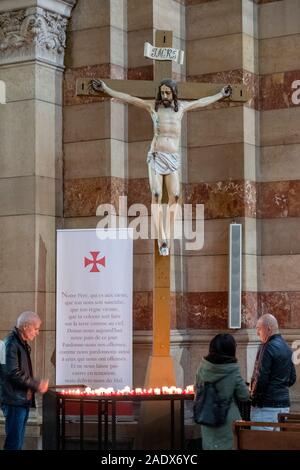 Bougies d'éclairage les gens sous une statue de Jésus Christ sur la croix à l'intérieur de la Cathédrale La Major de la cathédrale Sainte-Marie-Majeure, Marseille, France Banque D'Images