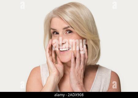 Femme de l'amour heureux de toucher sa peau sur le visage Banque D'Images