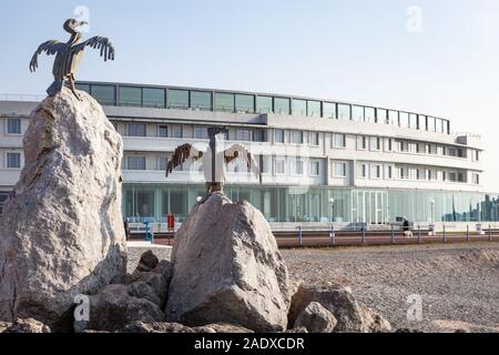 Cormoran de Morecambe Sculptures. Sur la pierre jetée dans le Lancashire ville balnéaire avec la promenade et Art Déco de l'hôtel Midland derrière. Banque D'Images