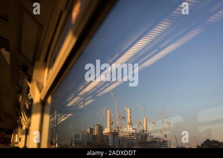 Vu de la fenêtre, siège d'un train qui roule vers la gare de Victoria, est un paysage de grues et de portiques à la Battersea Power Station grand site de construction, à Londres, en Angleterre, le 4 décembre 2019. Banque D'Images