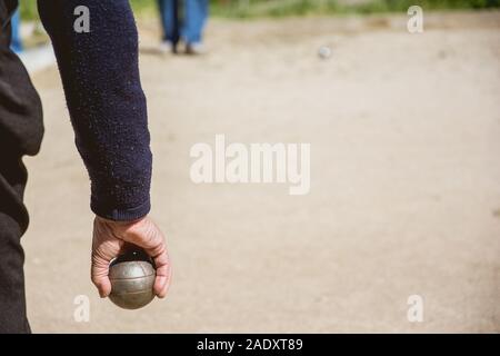 Les cadres prêts à jeter la boule de pétanque dans un parc de jeux à l'extérieur Banque D'Images