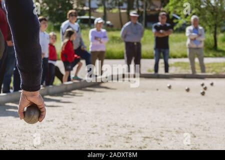 Les cadres prêts à jeter la boule de pétanque dans un parc de jeux à l'extérieur Banque D'Images