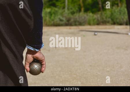 Les cadres prêts à jeter la boule de pétanque dans un parc de jeux à l'extérieur Banque D'Images