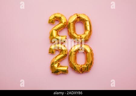 Nouvelle Année 2020 célébration. Parti feuille d'or sur fond rose pastel ballons Banque D'Images