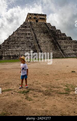 Un petit garçon se trouve en face d'El Castillo / Temple de Kukulcan (la principale pyramide) à Chichen Itza une ancienne civilisation maya, Yucatan, Mexique Banque D'Images