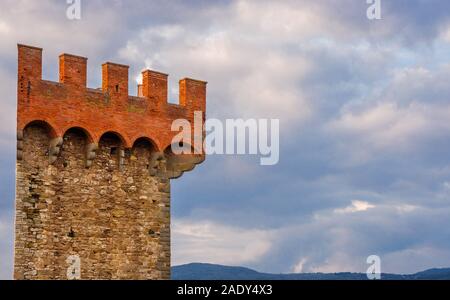 L'emblématique et triangulaires 14e siècle Torre di Ponente (Tour ouest) de Passignano sul Trasimeno murailles antiques ruines en Ombrie (avec des nuages et des c Banque D'Images